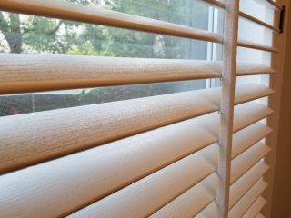 Bedroom with wooden blinds for windows.